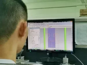 Uma pessoa visualiza o modelo de uma peça em uma estação de projeto na fotografia original